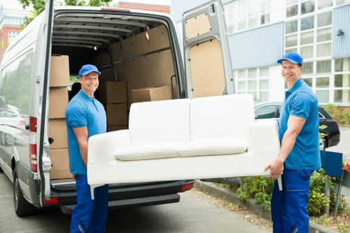 Removal team loading boxes and furniture into a vehicle