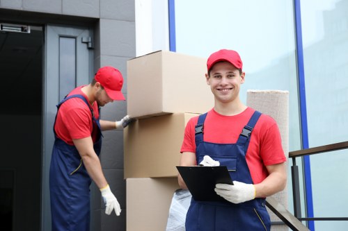 Trained movers lifting furniture safely in a Catford property